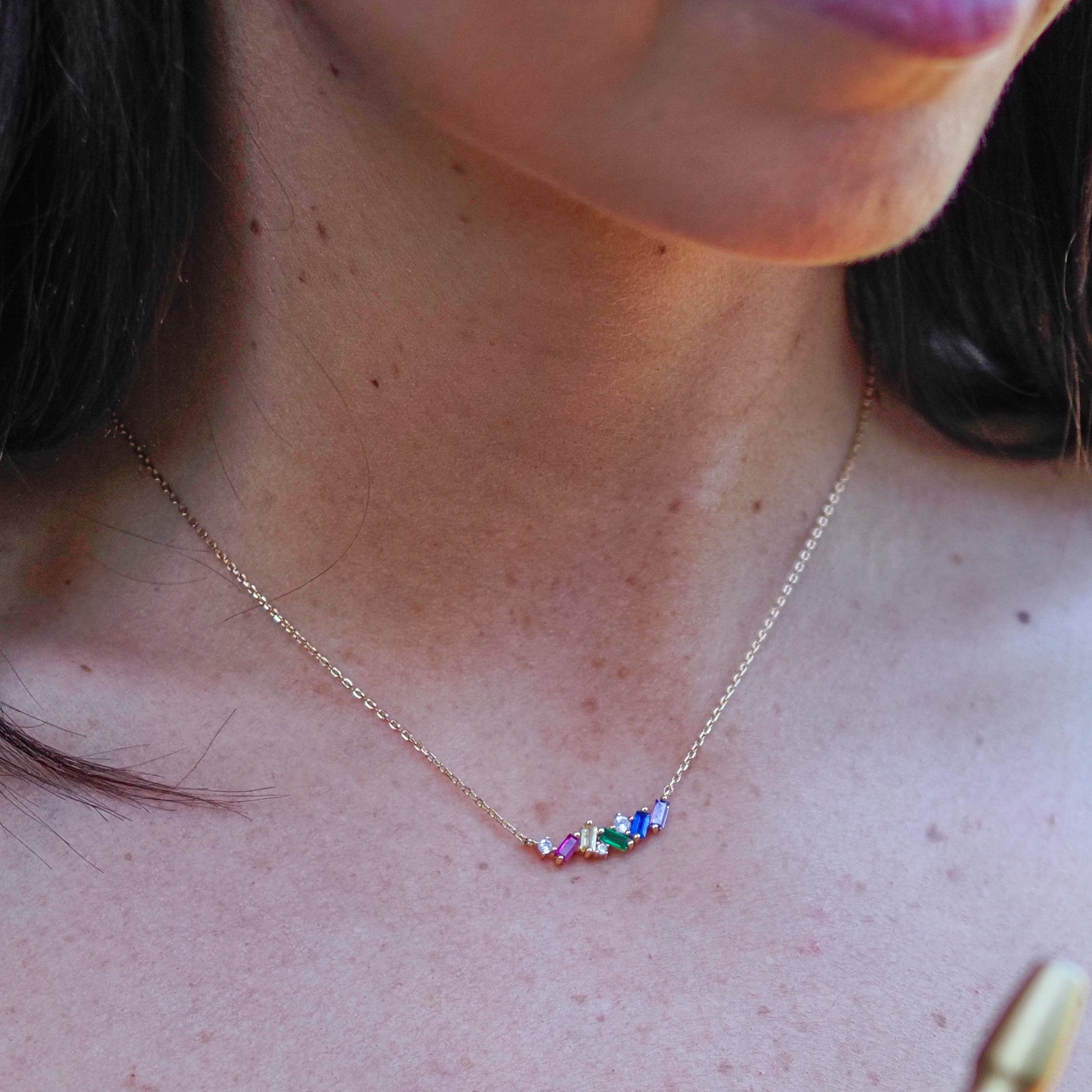 Rainbow Collision Necklace featuring rainbow colours from the LGBT pride flag, model