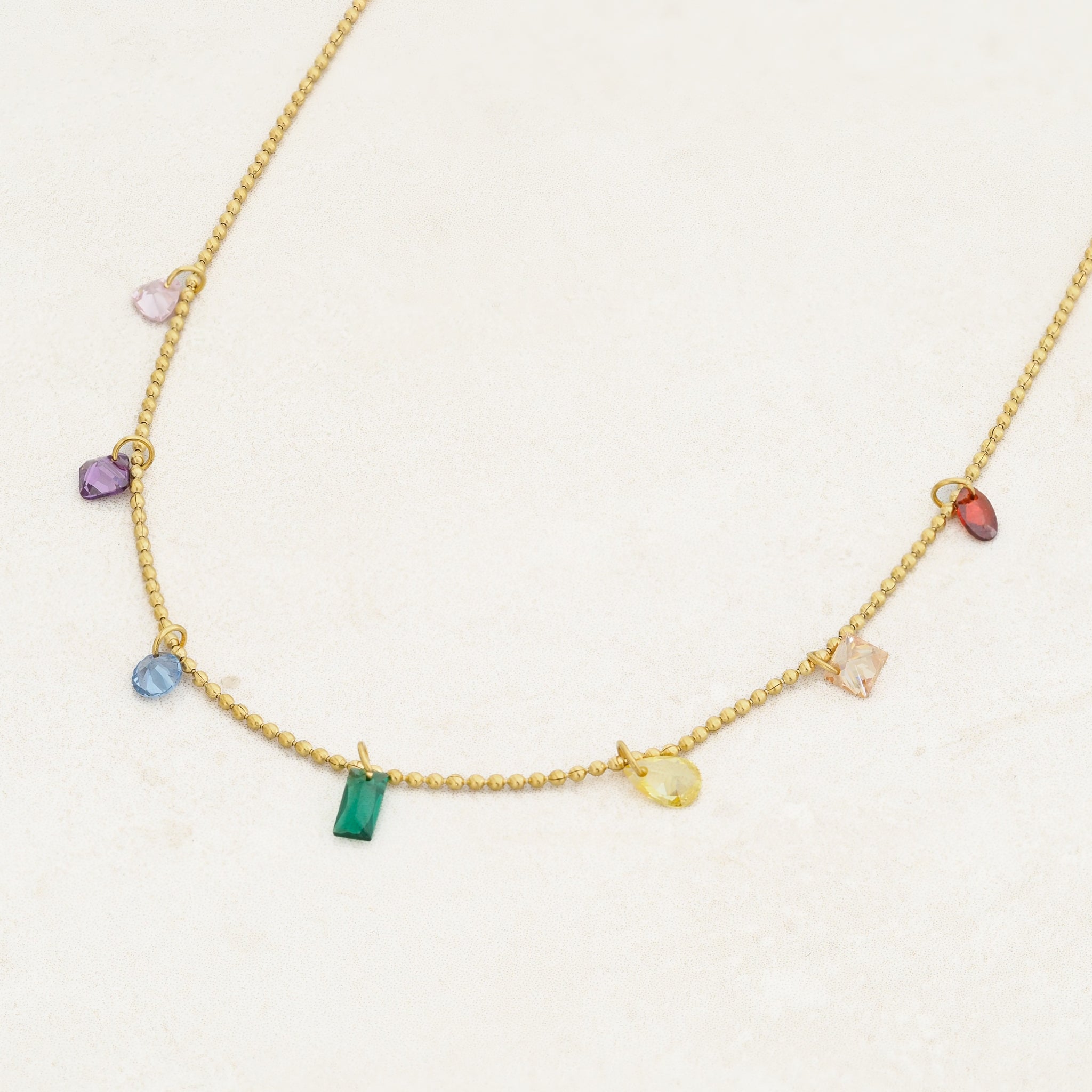 Rainbow pride necklace featuring droplets with colours from the rainbow pride flag, close