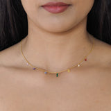 Rainbow pride necklace featuring droplets with colours from the rainbow pride flag, model