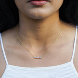 Transgender necklace in line style with trans flag colour scheme on model